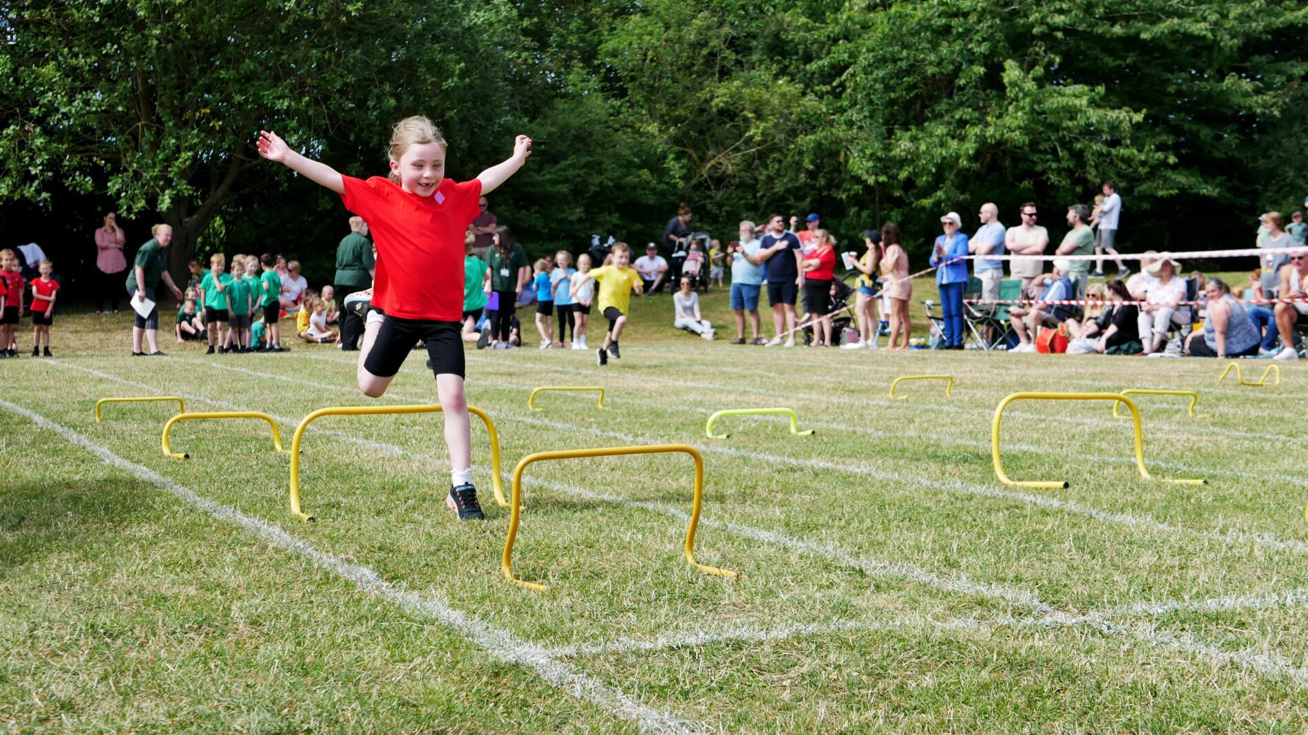 P1130669 physical education with a girl jumping over hurdles at sports day