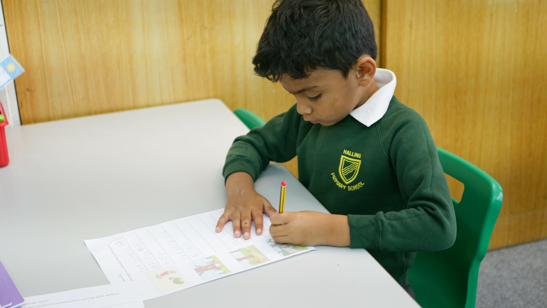 P1170377 pupil writing on a worksheet with phonics at halling primary school