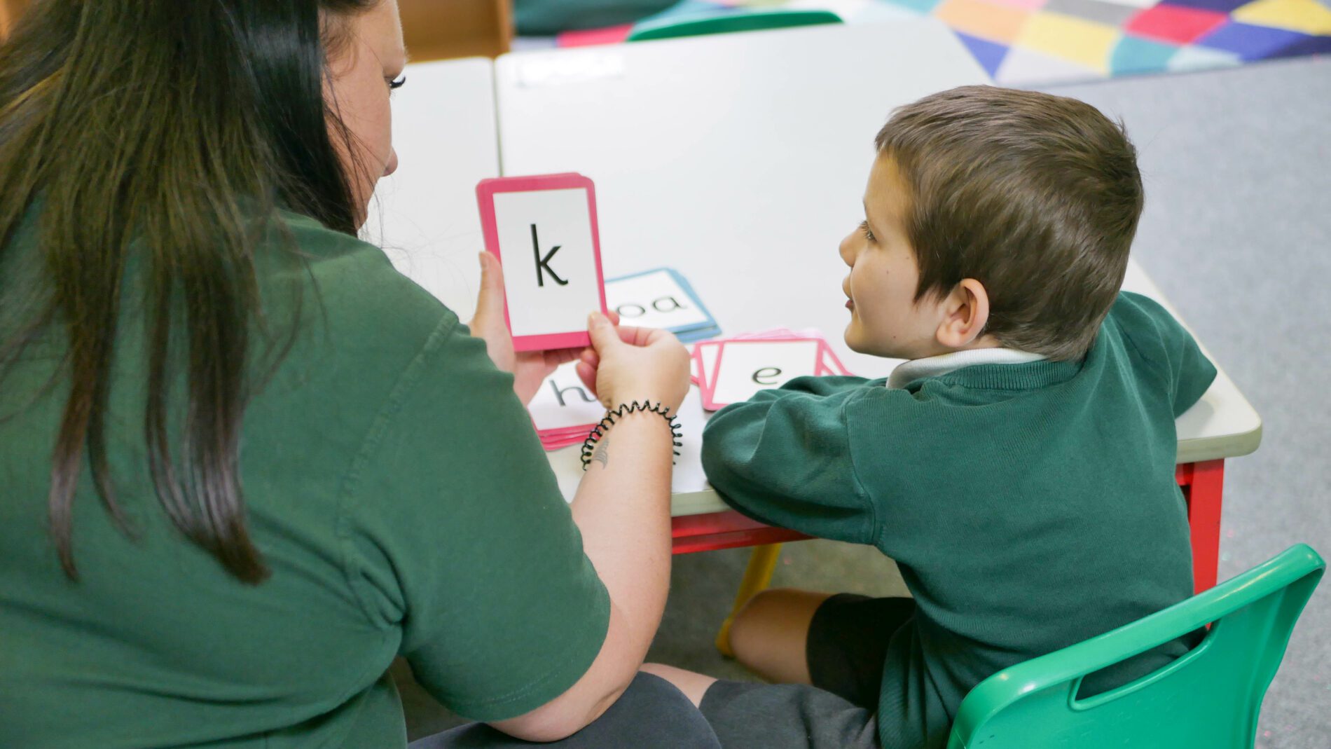 teacher helping pupil learn phonics at halling primary school