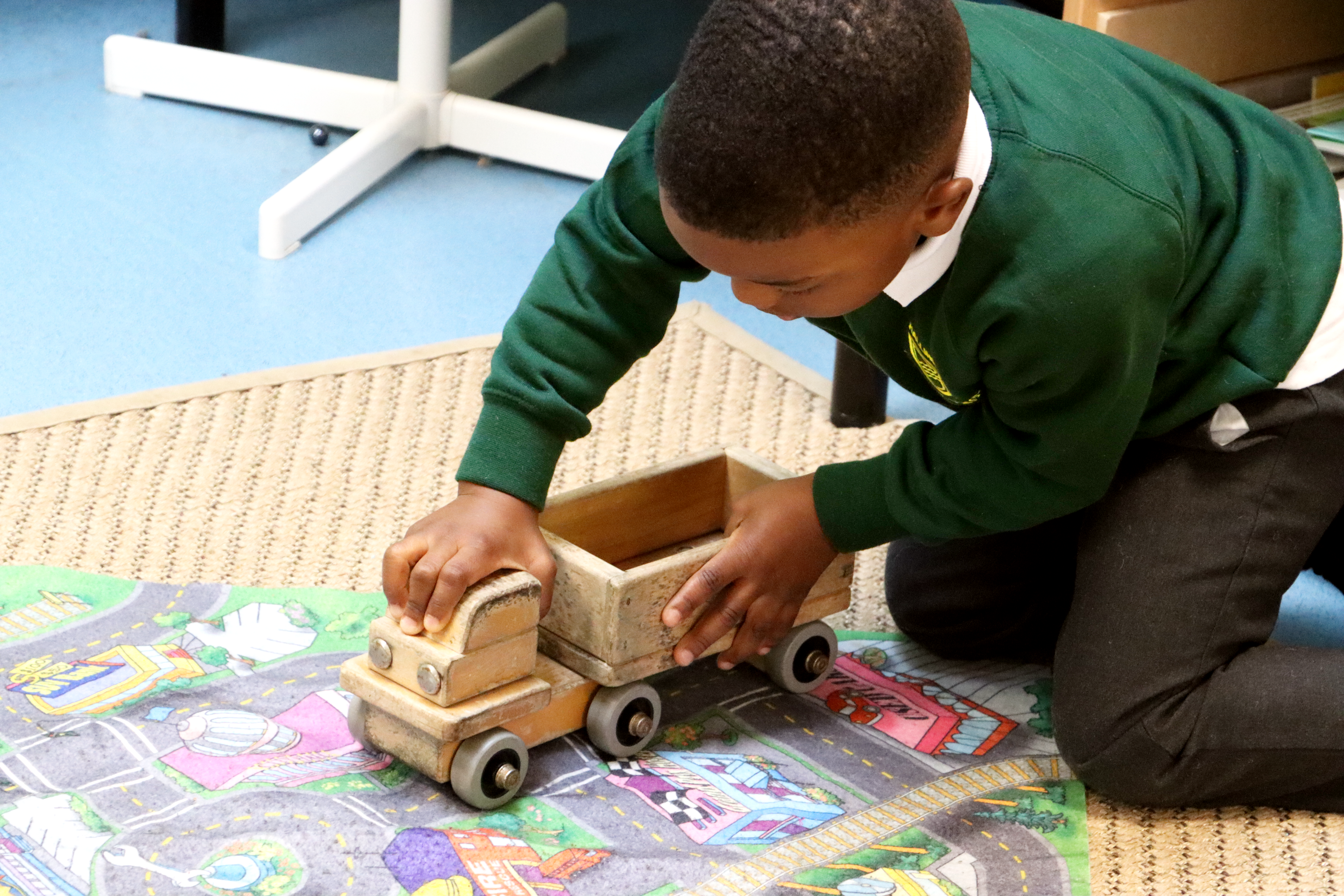 pupil in eyfs playing with van