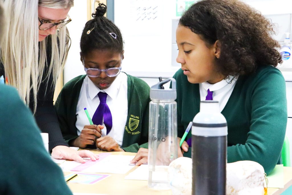 teacher helping pupils in lesson at halling primary school